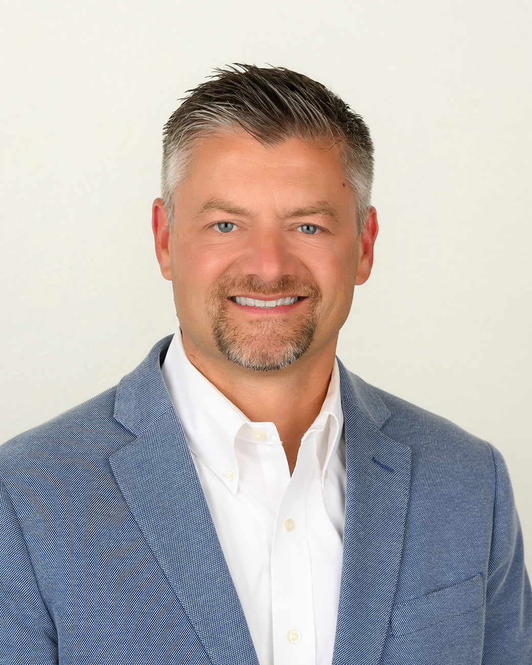 Man smiling with blue suit coat and white shirt